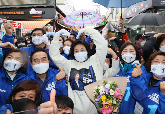 박영선 민주당 서울시장 후보가 주말인 27일 서울 중랑구 동원시장 앞에서 열린 중랑구 집중유세에서 소상공인 만들어 선물한 티셔츠를 입고 지지자들과 함께 기념촬영하고 있다. 연합뉴스